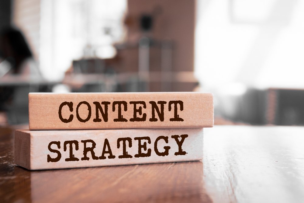 Wooden blocks spelling Content Strategy on a desk representing a business content strategy guide